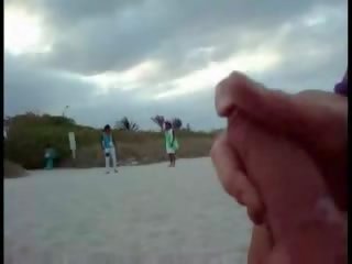 Americano turista segarsi su il spiaggia mentre donna passing da video